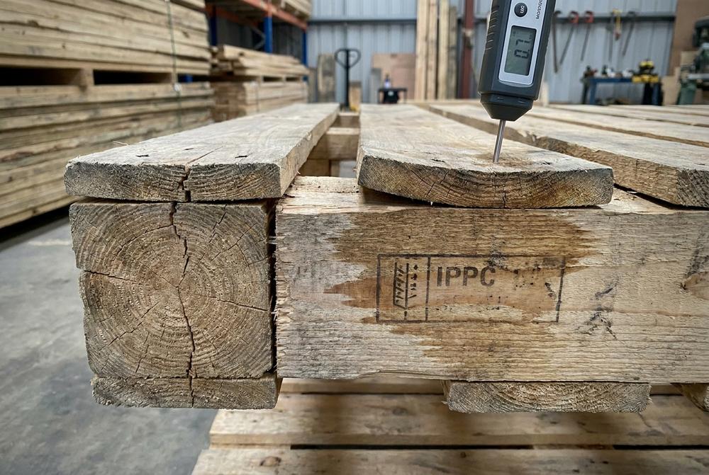 Holzpaletten direkt in großen Stapeln für Logistik, Produktion und E-Commerce in der Fertigung